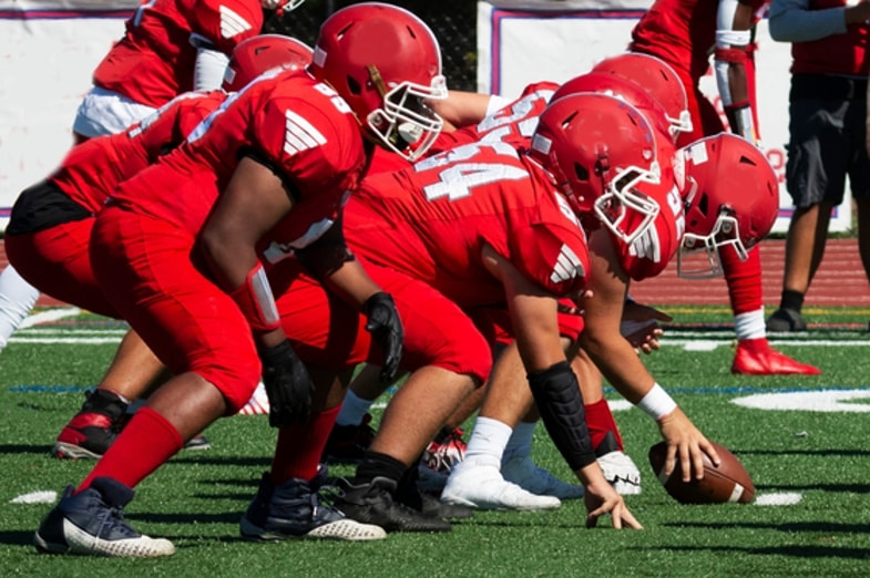 American Football Team huddled together