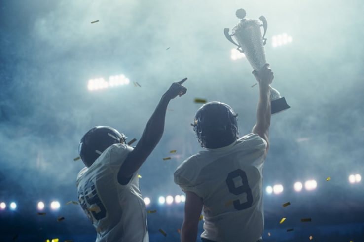 American football player holding a trophy